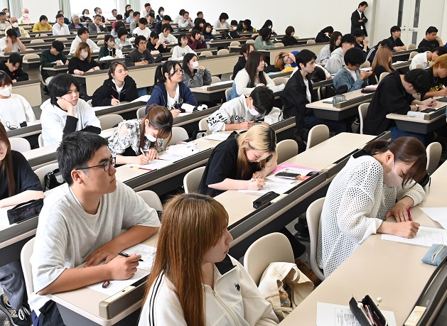 熱心に講演のメモを取る学生たち