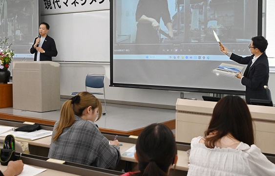 超硬合金包丁のPR映像を流し、高い品質を紹介する福田氏(左)