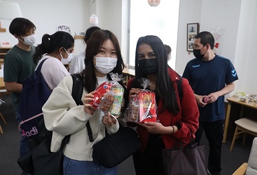 １等の豪華お菓子詰め合わせを獲得した日本人学生と留学生【関C】
