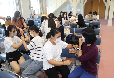 ２人１組で知恵の輪を行う留学生と日本人学生