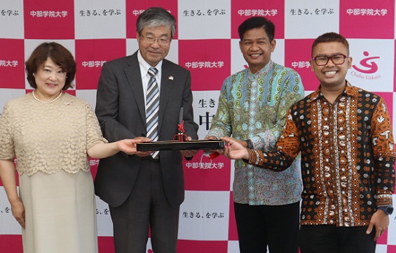 友好の印として関のはさみを贈呈する江馬学長ら=関キャンパス
