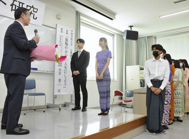 感謝のセレモニーでお礼の言葉を述べ、花束を贈る奨 学生代表ら
