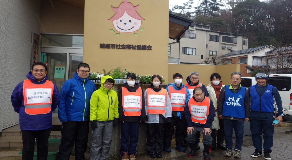 輪島市社協前での支援活動を行なった教職員と輪島市社協の局長ほかの集合写真